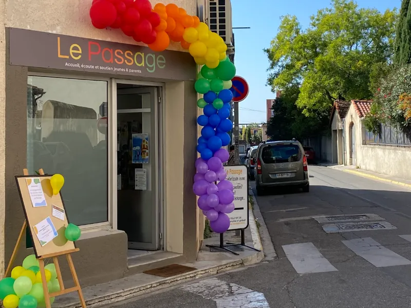 Devanture Paej Le Passage décorée de ballons multicolores.